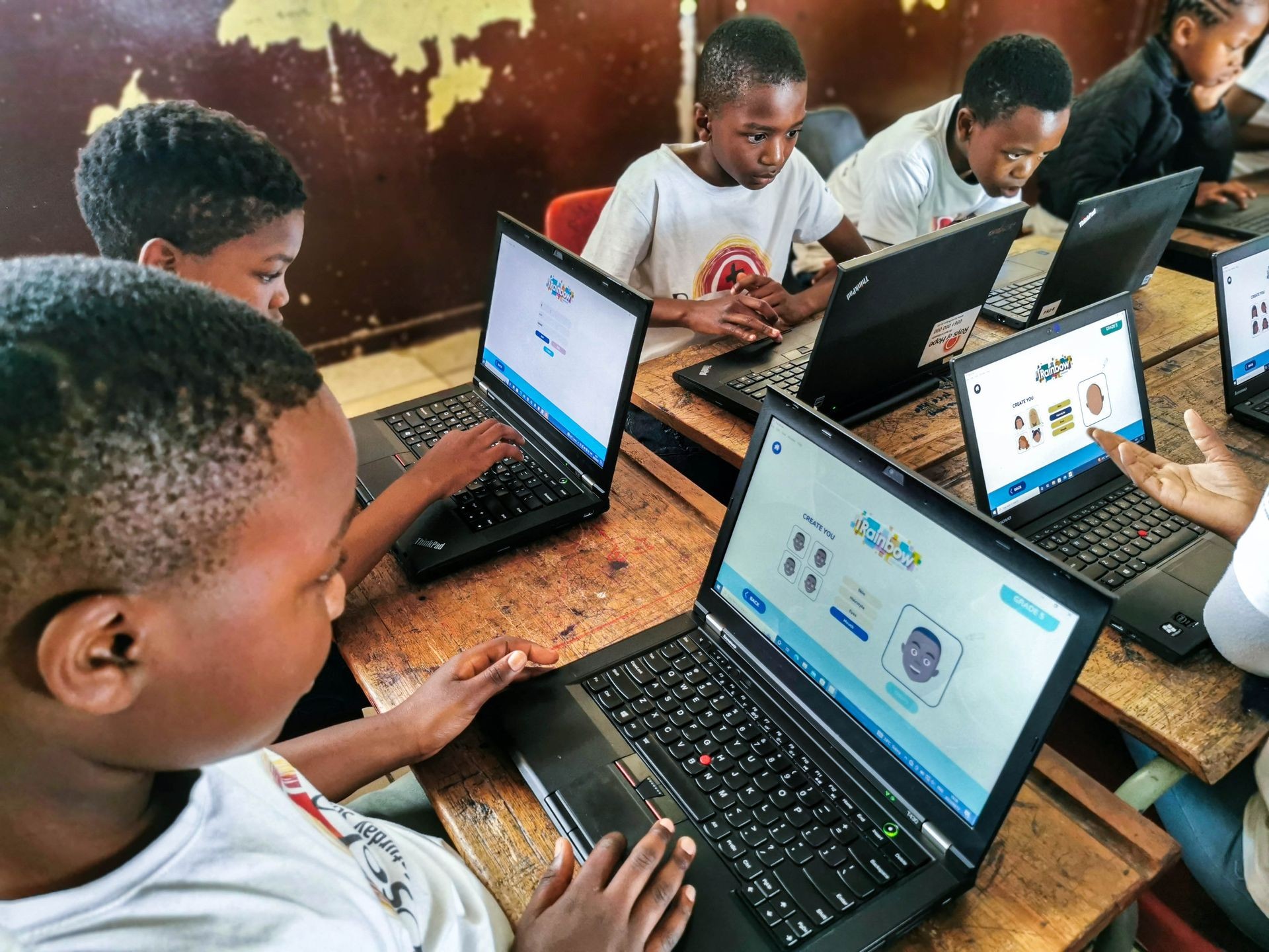 Children focused on laptops during a computer class, engaging with educational software.